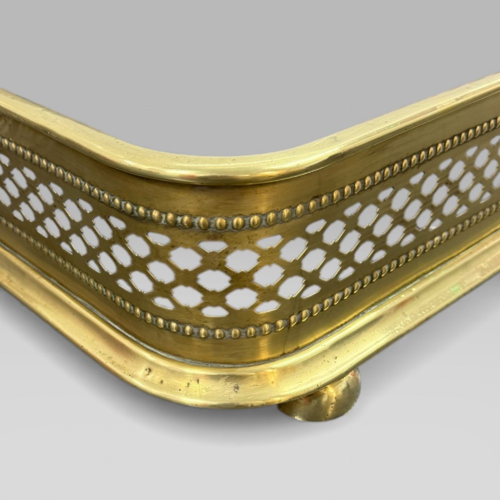 A long Victorian brass fire fender featuring a pierced lattice pattern, beaded edge trim, and low support feet. View VIII