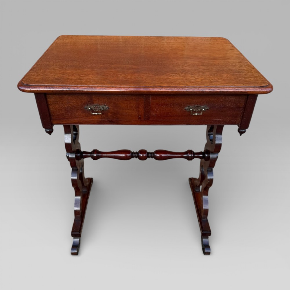 A Victorian mahogany centre table featuring a rectangular top with moulded edge, two frieze drawers with brass drop handles, carved shaped end supports, and a turned stretcher. View II