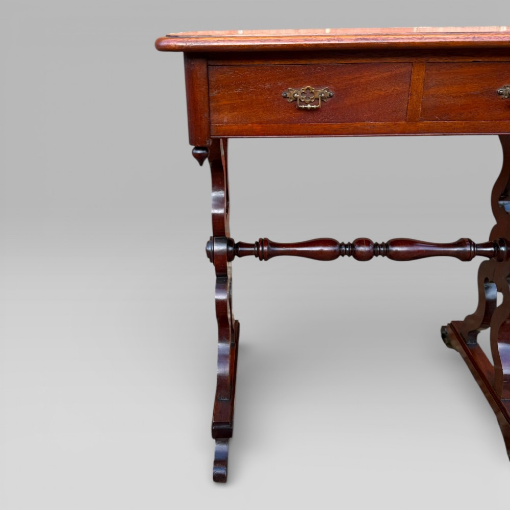 A Victorian mahogany centre table featuring a rectangular top with moulded edge, two frieze drawers with brass drop handles, carved shaped end supports, and a turned stretcher. View III