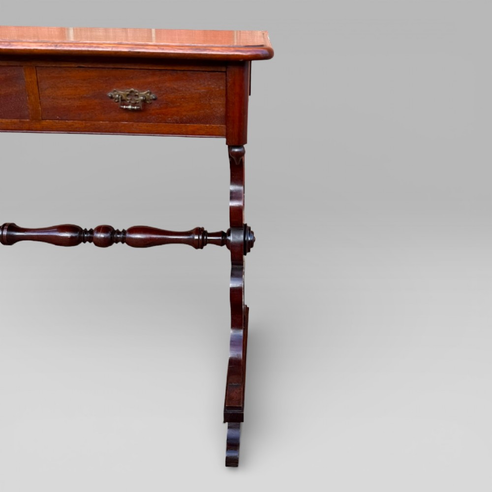 A Victorian mahogany centre table featuring a rectangular top with moulded edge, two frieze drawers with brass drop handles, carved shaped end supports, and a turned stretcher. View IV