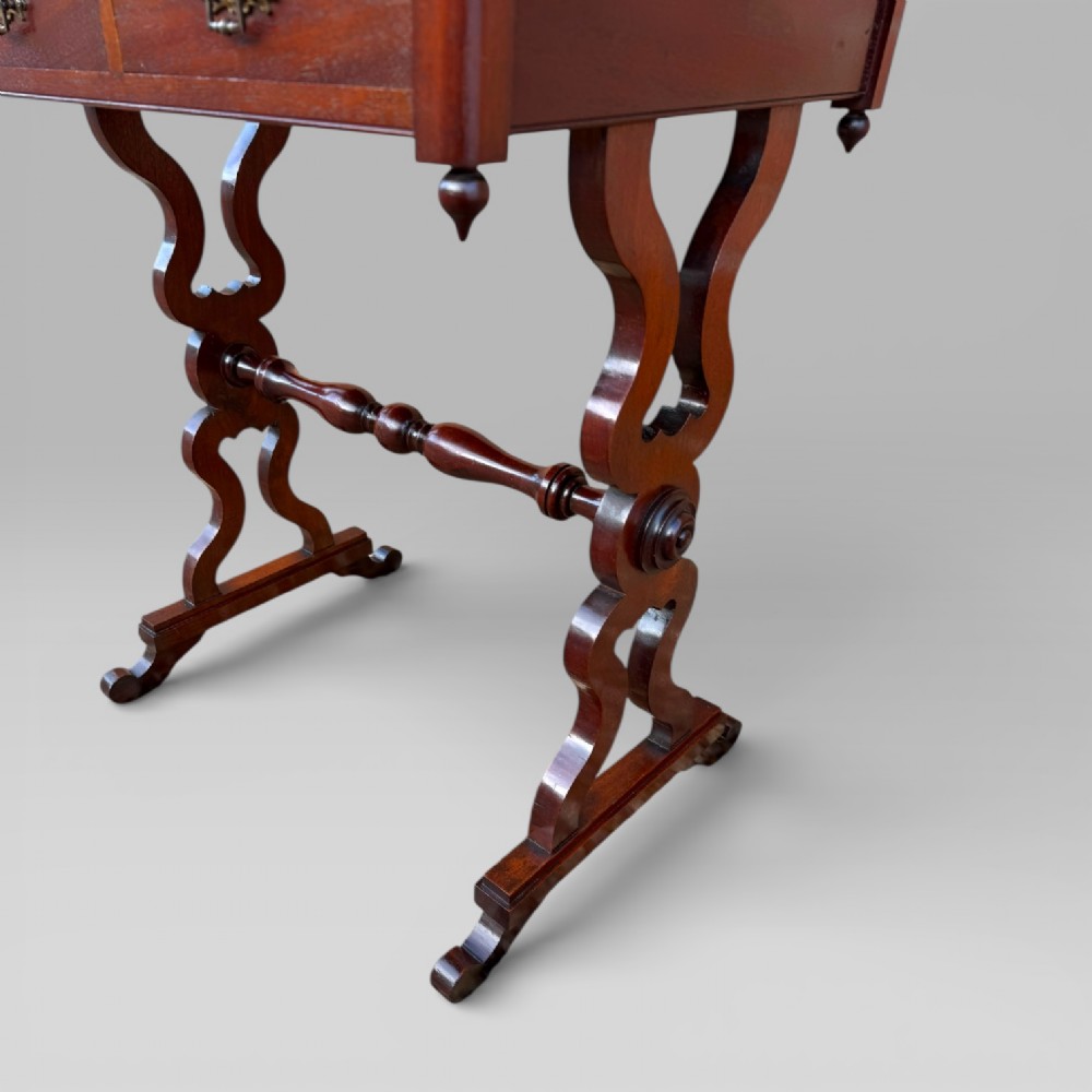 A Victorian mahogany centre table featuring a rectangular top with moulded edge, two frieze drawers with brass drop handles, carved shaped end supports, and a turned stretcher. View VIII