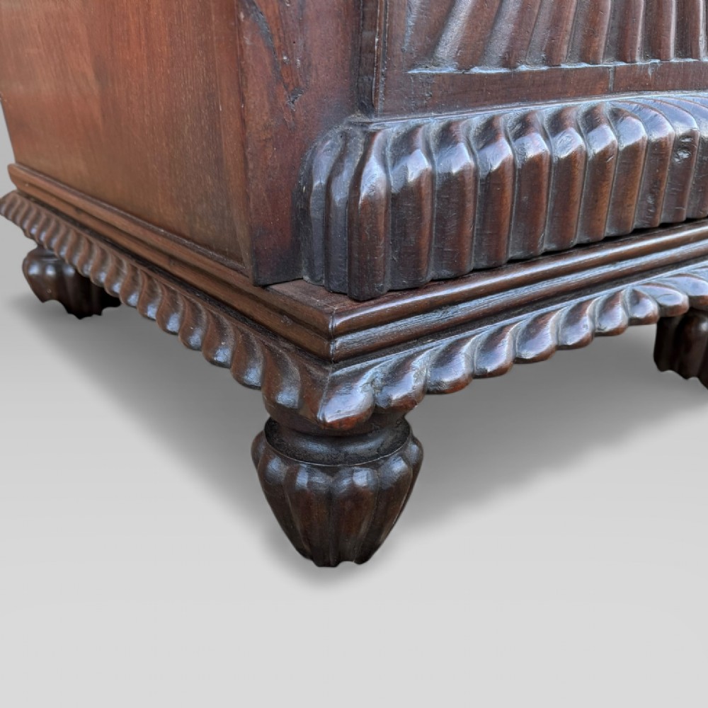 A dark carved padouk wood sideboard featuring intricate floral frieze carvings, sunburst panel pedestals, and a central kneehole design. View XII