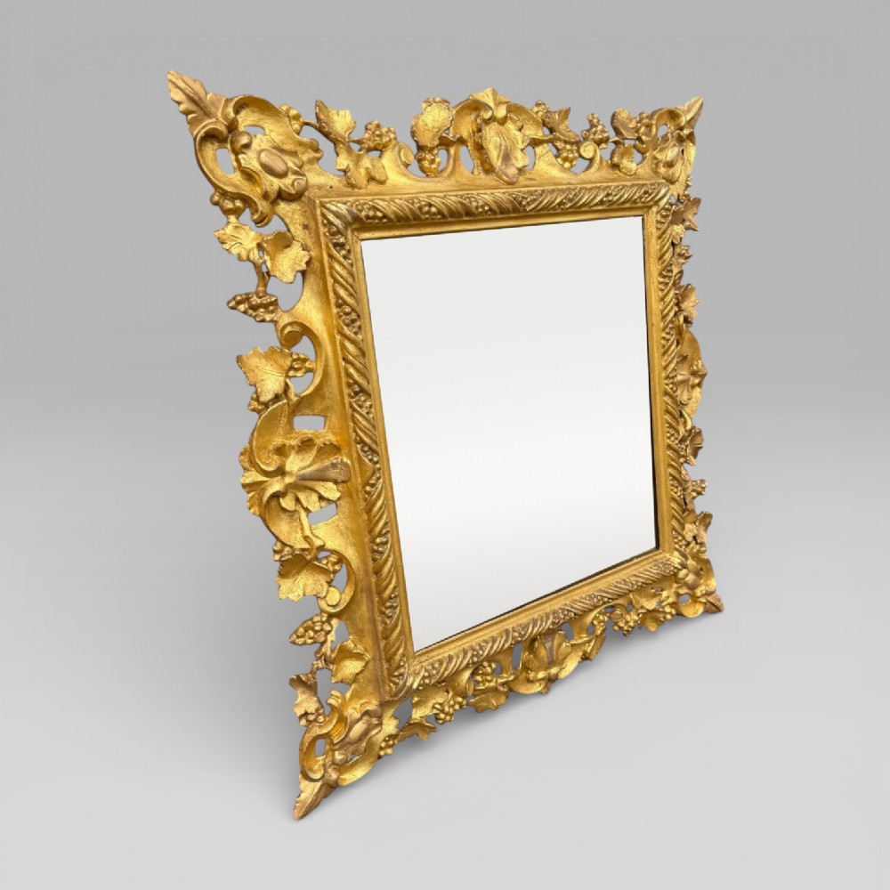 An ornate Victorian rectangular wall mirror featuring an intricately carved giltwood frame with openwork floral and scroll motifs. View III