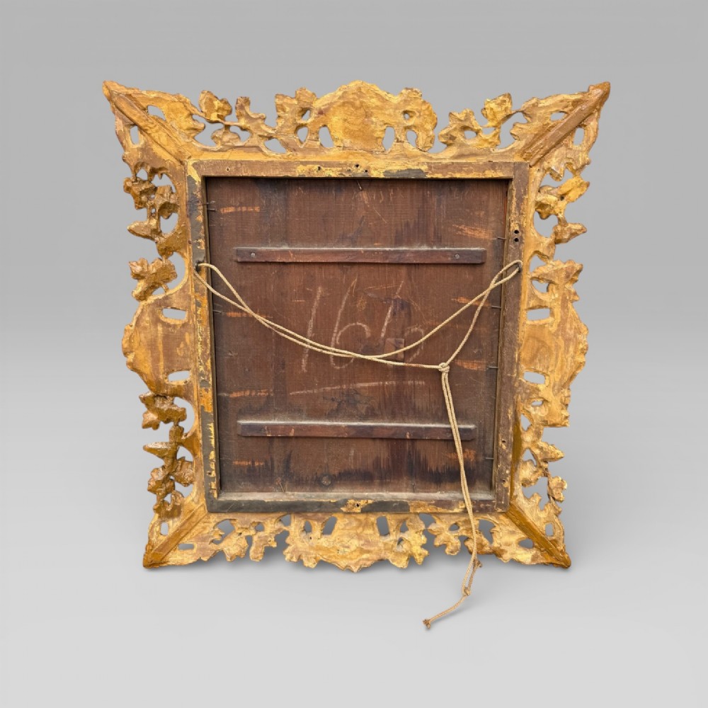 An ornate Victorian rectangular wall mirror featuring an intricately carved giltwood frame with openwork floral and scroll motifs. View X