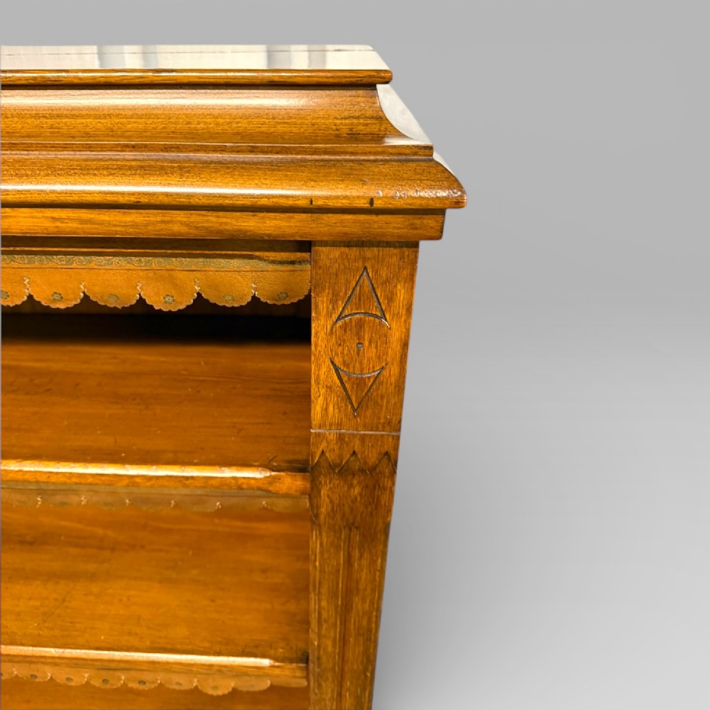 A late Victorian open bookcase crafted from golden oak, featuring scalloped edging along each shelf and subtle geometric carvings on the pilasters. View VIII
