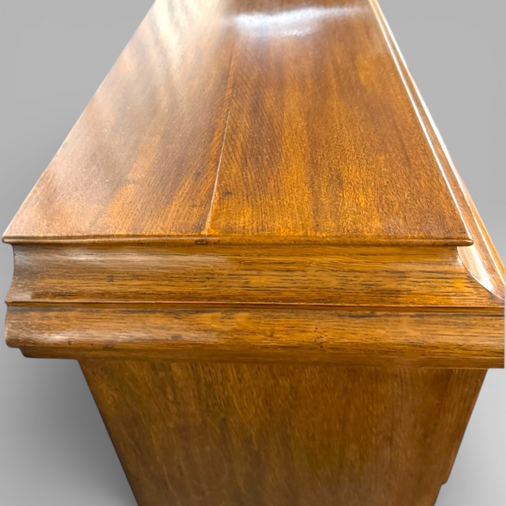 A late Victorian open bookcase crafted from golden oak, featuring scalloped edging along each shelf and subtle geometric carvings on the pilasters. View IX