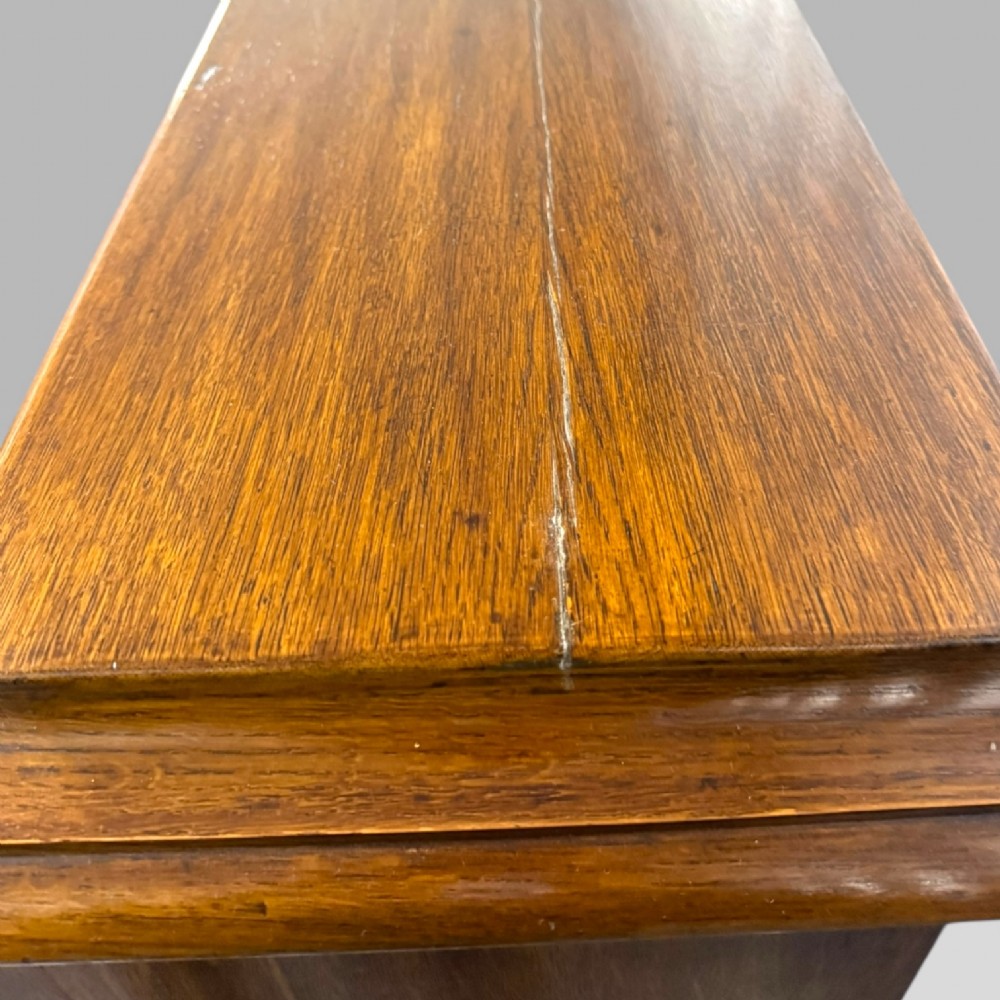 A late Victorian open bookcase crafted from golden oak, featuring scalloped edging along each shelf and subtle geometric carvings on the pilasters. View X