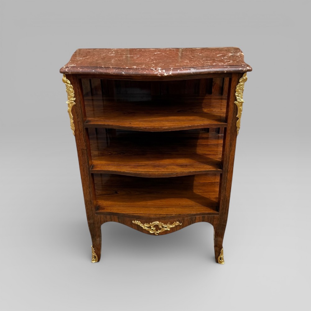 A French Louis XV style rosewood open side cabinet featuring a red marble top, three tiered shelves, and decorative brass ormolu mounts.