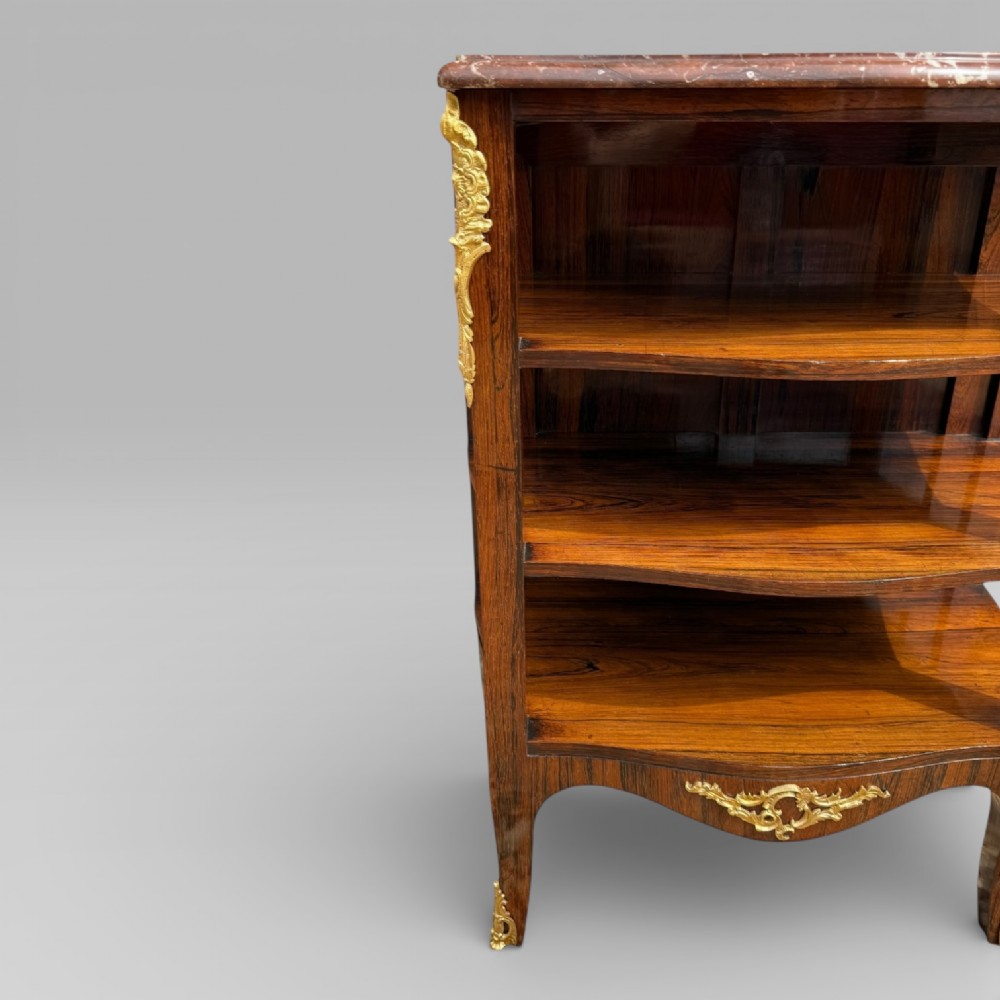 A French Louis XV style rosewood open side cabinet featuring a red marble top, three tiered shelves, and decorative brass ormolu mounts. View V
