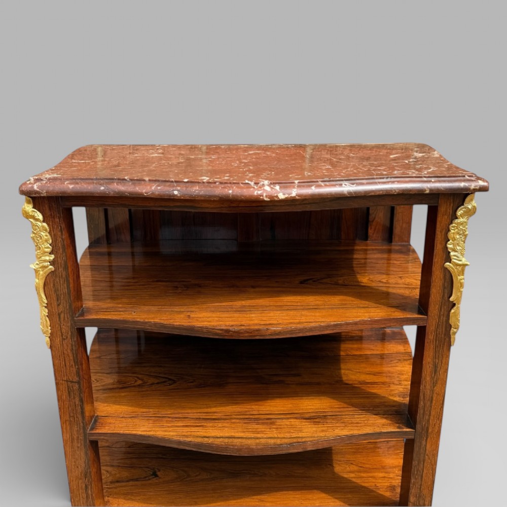 A French Louis XV style rosewood open side cabinet featuring a red marble top, three tiered shelves, and decorative brass ormolu mounts. View VI
