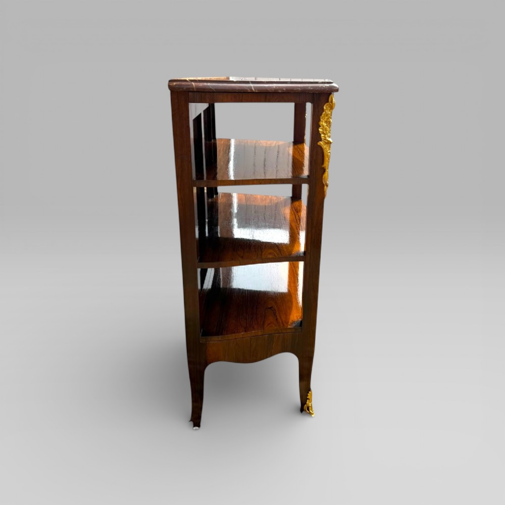 A French Louis XV style rosewood open side cabinet featuring a red marble top, three tiered shelves, and decorative brass ormolu mounts. View XIII