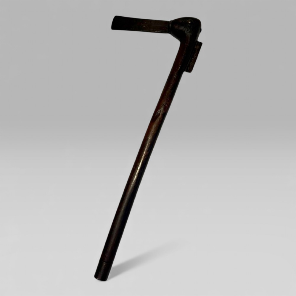 A 19th-century Dahomey messenger recade axe featuring an angled hardwood shaft and a flat iron blade.