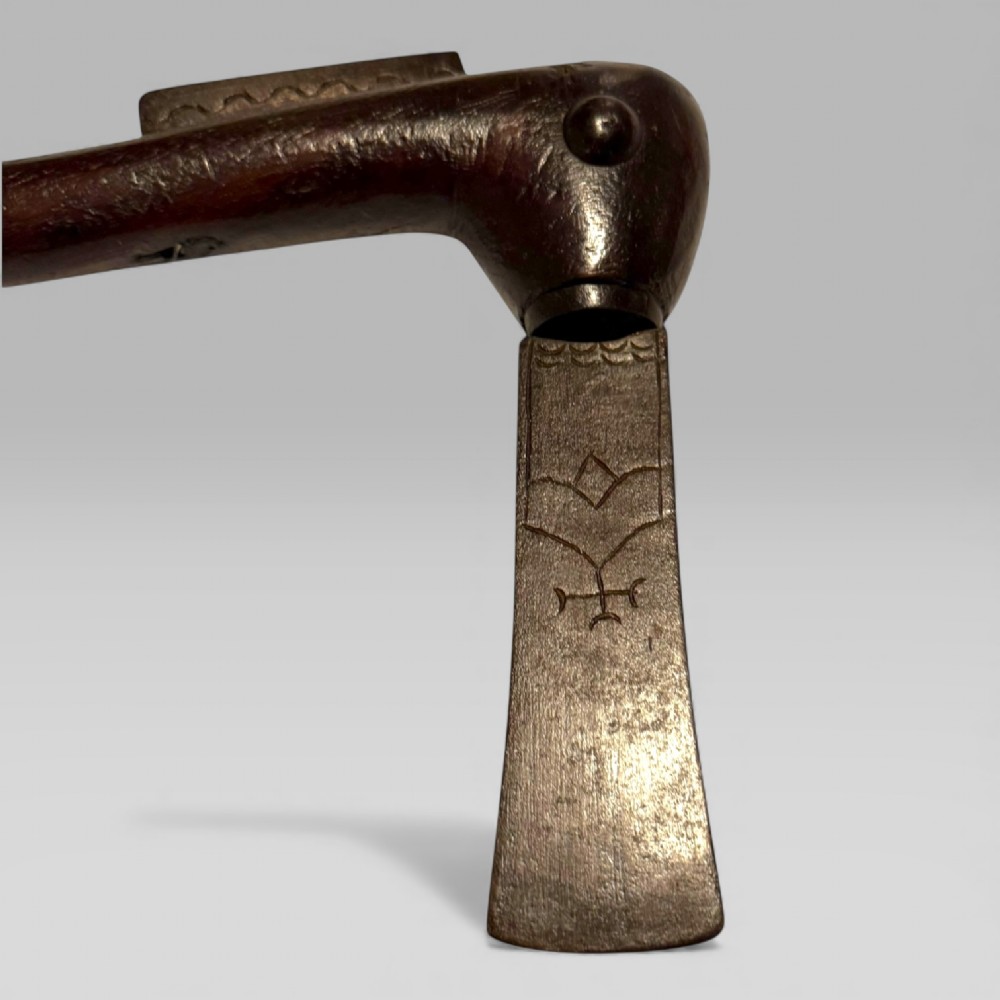 A 19th-century Dahomey messenger recade axe featuring an angled hardwood shaft and a flat iron blade. View IV