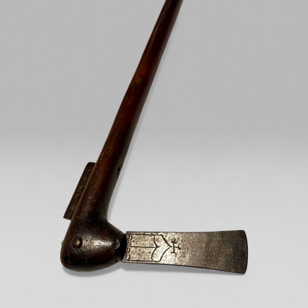 A 19th-century Dahomey messenger recade axe featuring an angled hardwood shaft and a flat iron blade. View V
