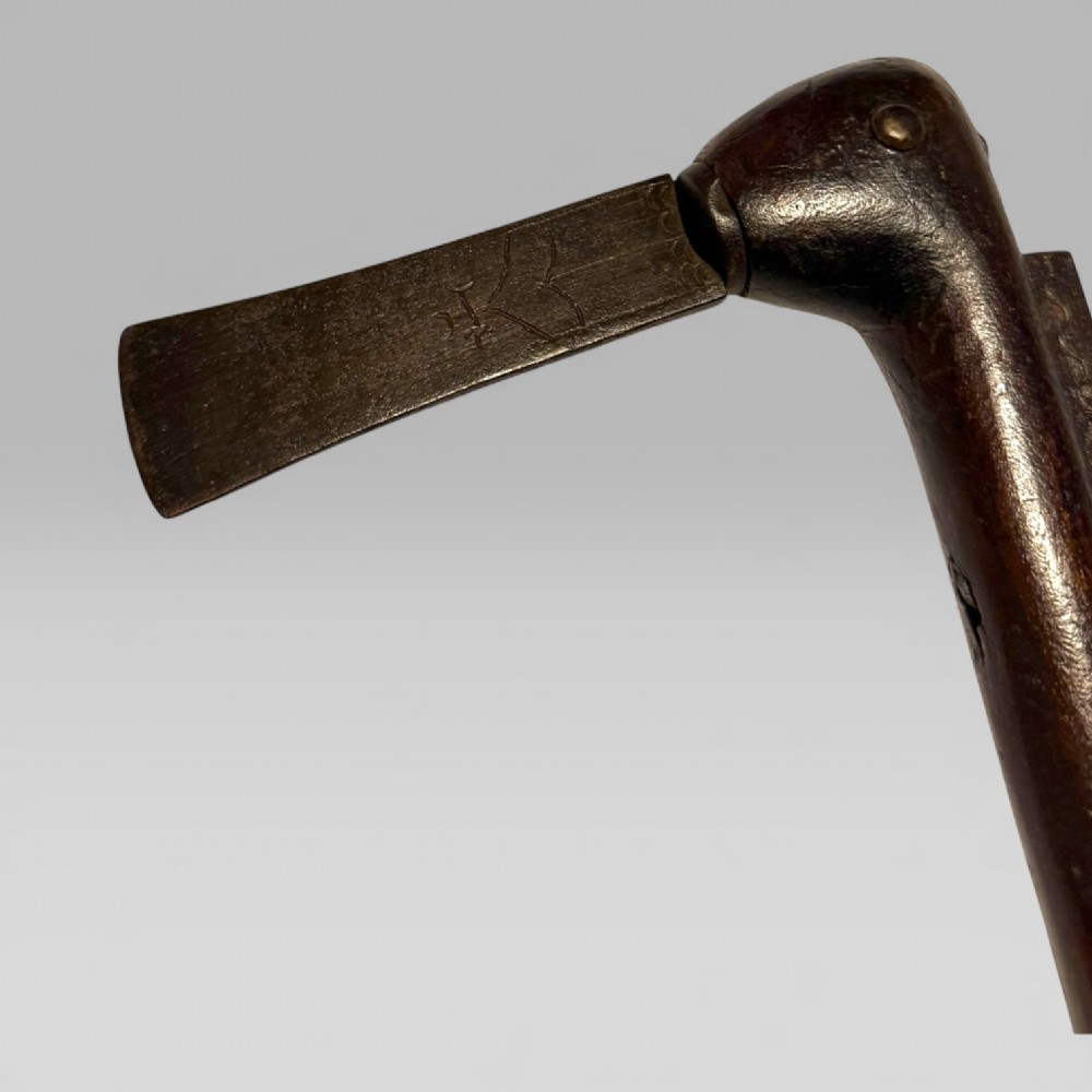 A 19th-century Dahomey messenger recade axe featuring an angled hardwood shaft and a flat iron blade. View IX