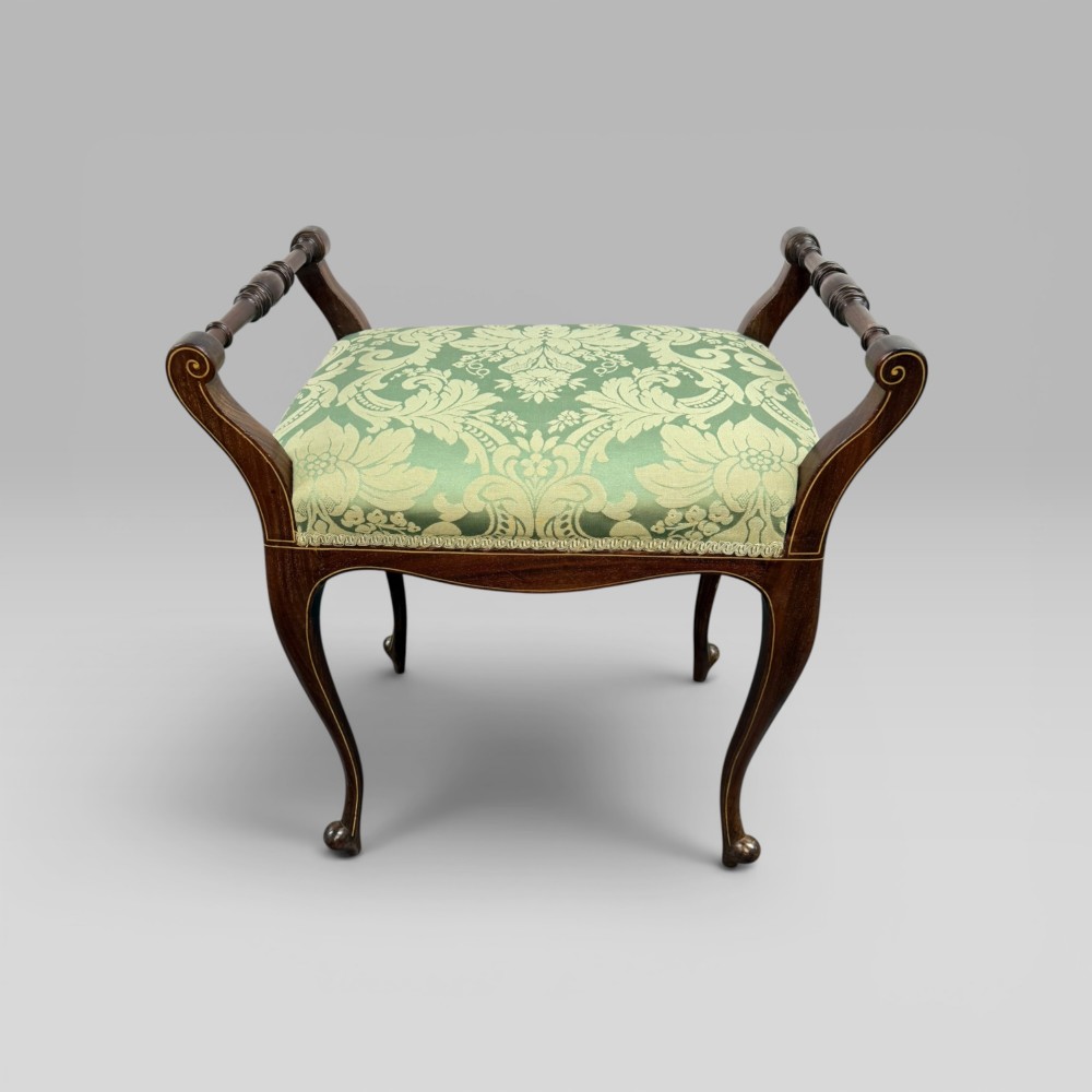 An antique mahogany piano stool featuring cabriole legs, fine line inlay, turned handles, and green floral damask upholstered seating. View II