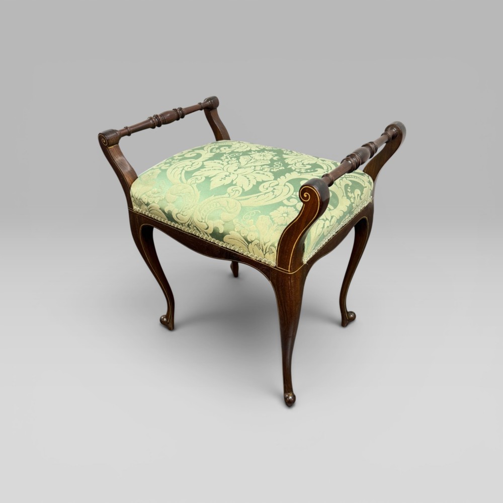 An antique mahogany piano stool featuring cabriole legs, fine line inlay, turned handles, and green floral damask upholstered seating. View III