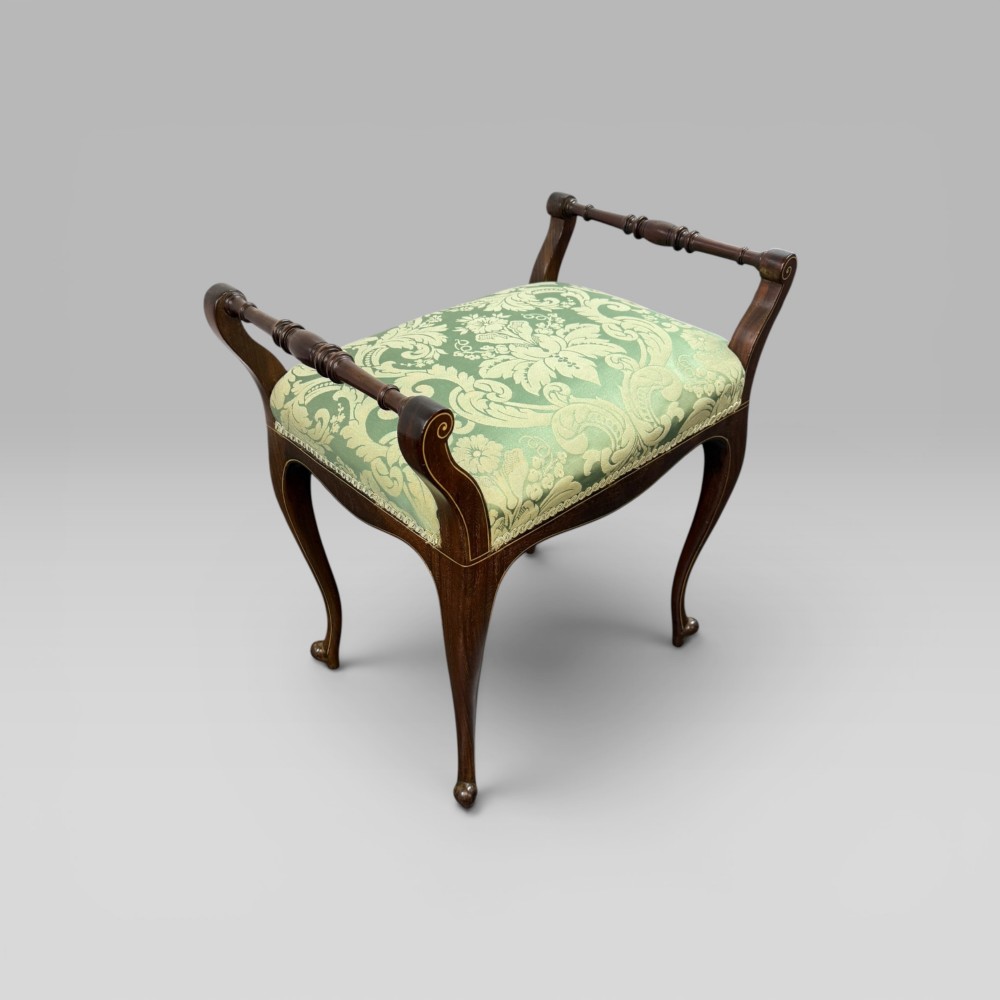 An antique mahogany piano stool featuring cabriole legs, fine line inlay, turned handles, and green floral damask upholstered seating. View IV
