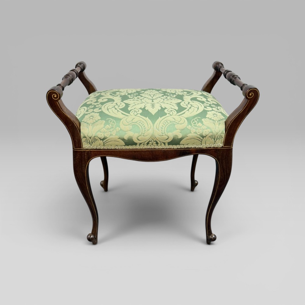 An antique mahogany piano stool featuring cabriole legs, fine line inlay, turned handles, and green floral damask upholstered seating. View V