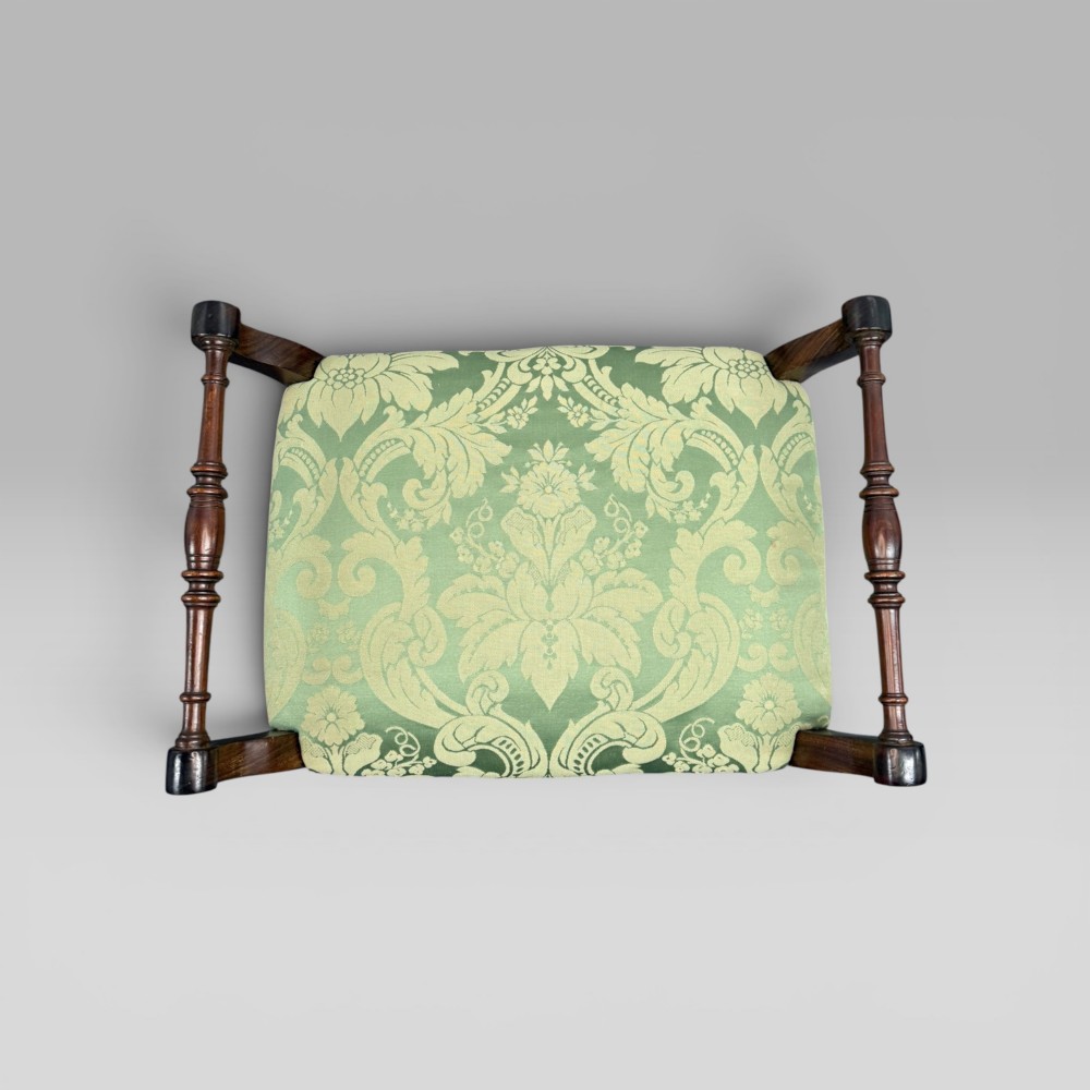 An antique mahogany piano stool featuring cabriole legs, fine line inlay, turned handles, and green floral damask upholstered seating. View VI