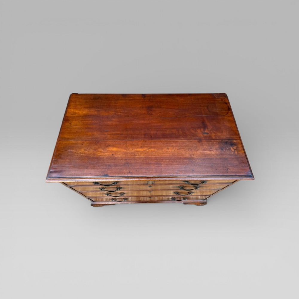 A late 18th-century George III mahogany chest of drawers featuring two short over three long drawers with brass swan-neck handles and bracket feet. View VI