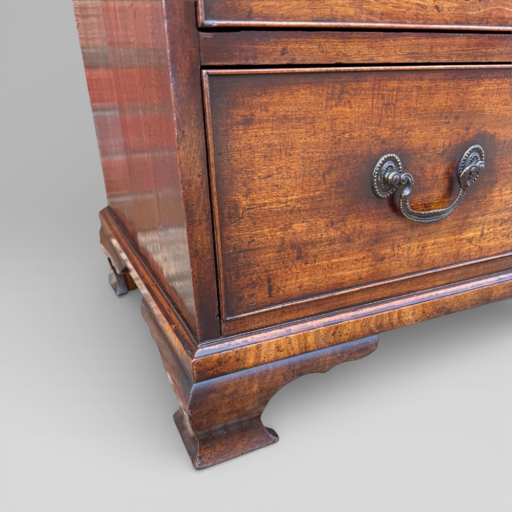 A late 18th-century George III mahogany chest of drawers featuring two short over three long drawers with brass swan-neck handles and bracket feet. View VIII