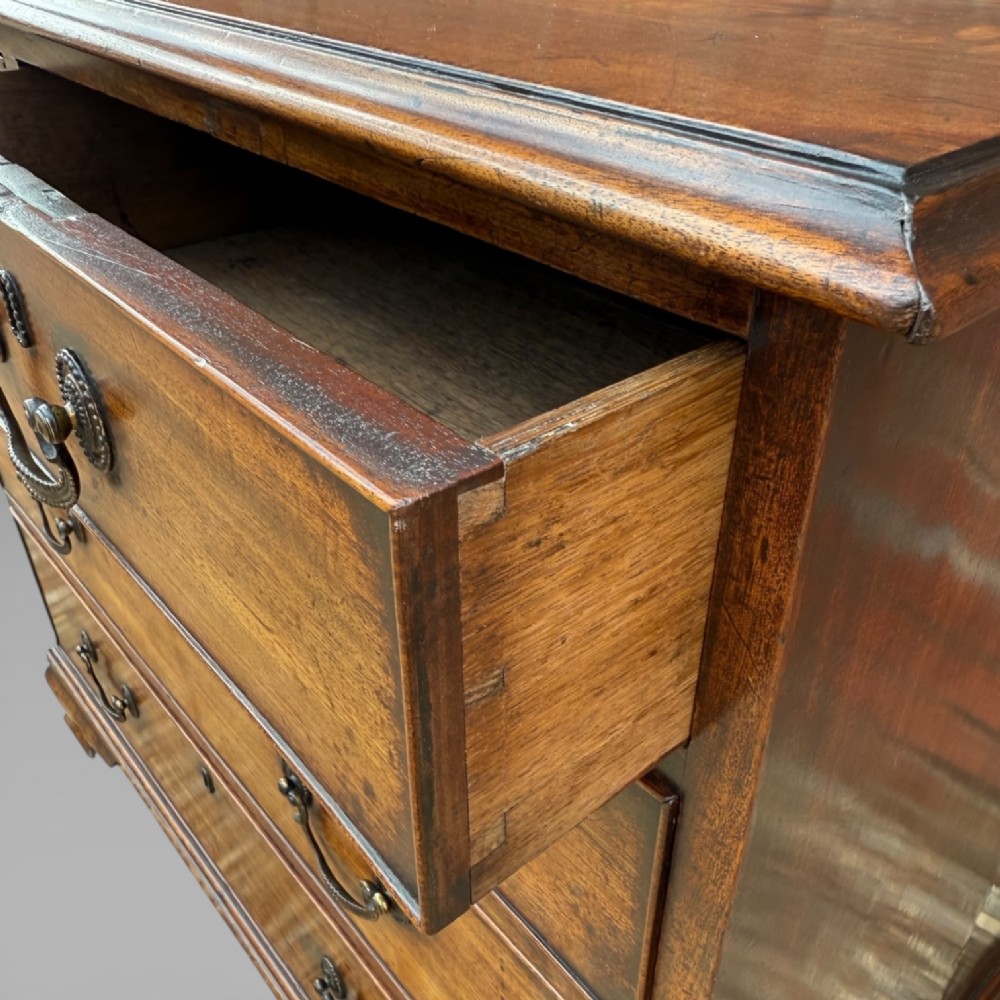 A late 18th-century George III mahogany chest of drawers featuring two short over three long drawers with brass swan-neck handles and bracket feet. View IX