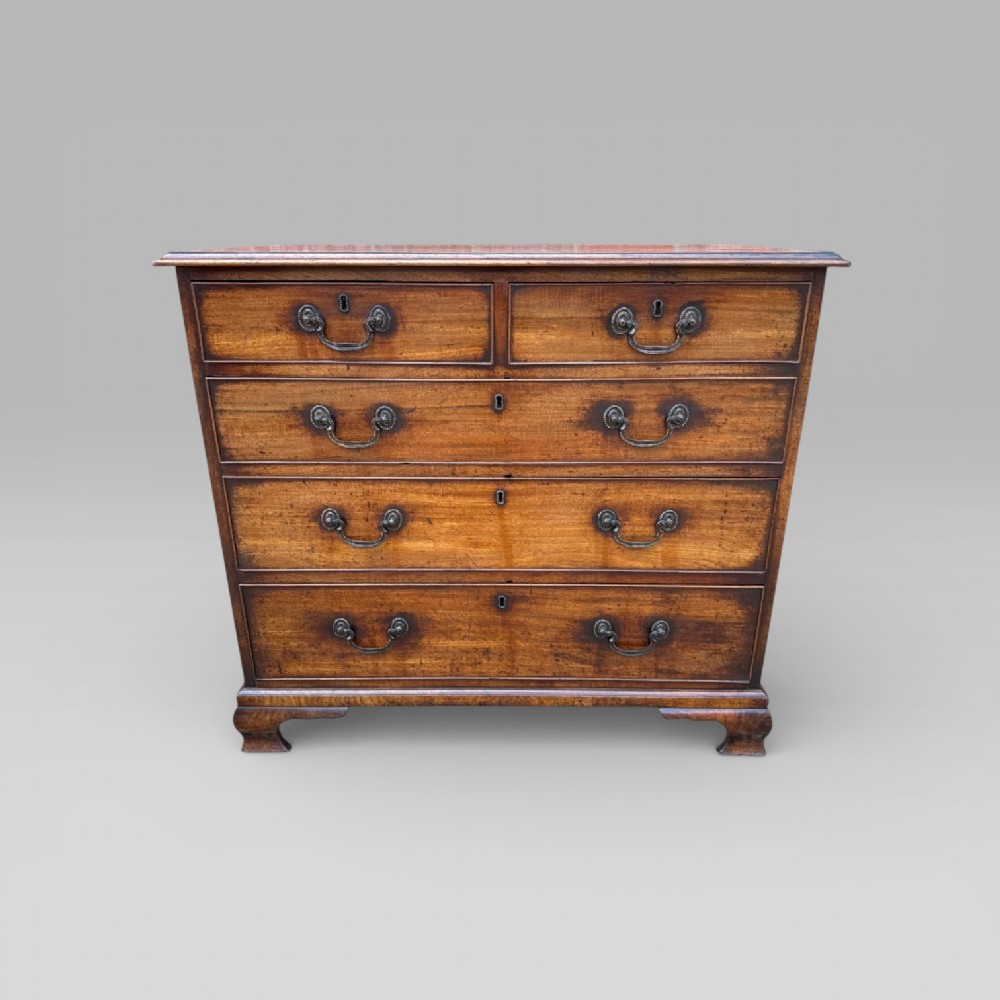 A late 18th-century George III mahogany chest of drawers featuring two short over three long drawers with brass swan-neck handles and bracket feet. View XV
