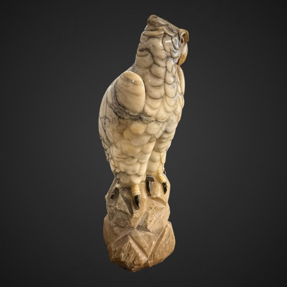 A 19th-century carved veined white marble eagle statue with amber glass eyes perched atop a rock formation. View XIII