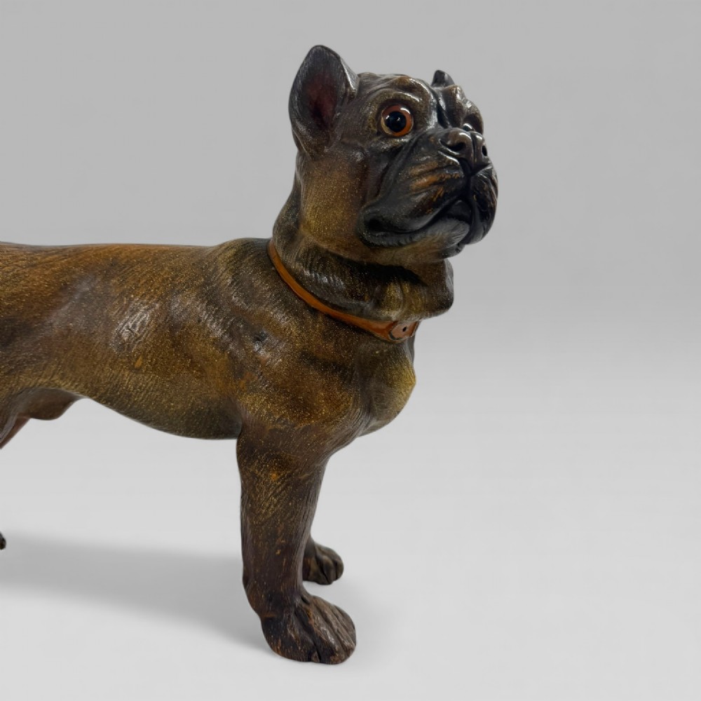 A dark brown painted terracotta dog sculpture standing upright with glass eyes and a moulded collar. View IV