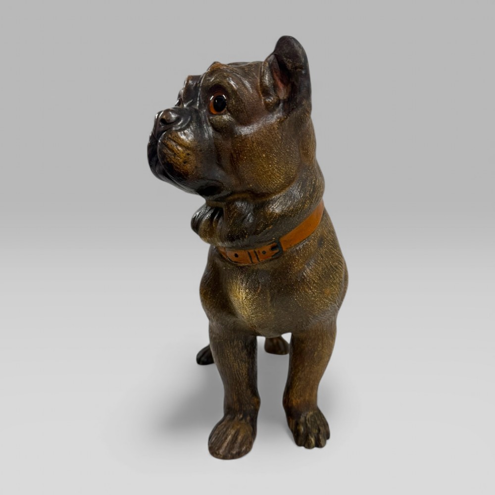 A dark brown painted terracotta dog sculpture standing upright with glass eyes and a moulded collar. View V