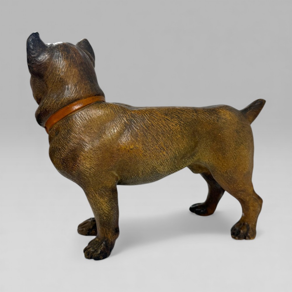 A dark brown painted terracotta dog sculpture standing upright with glass eyes and a moulded collar. View IX