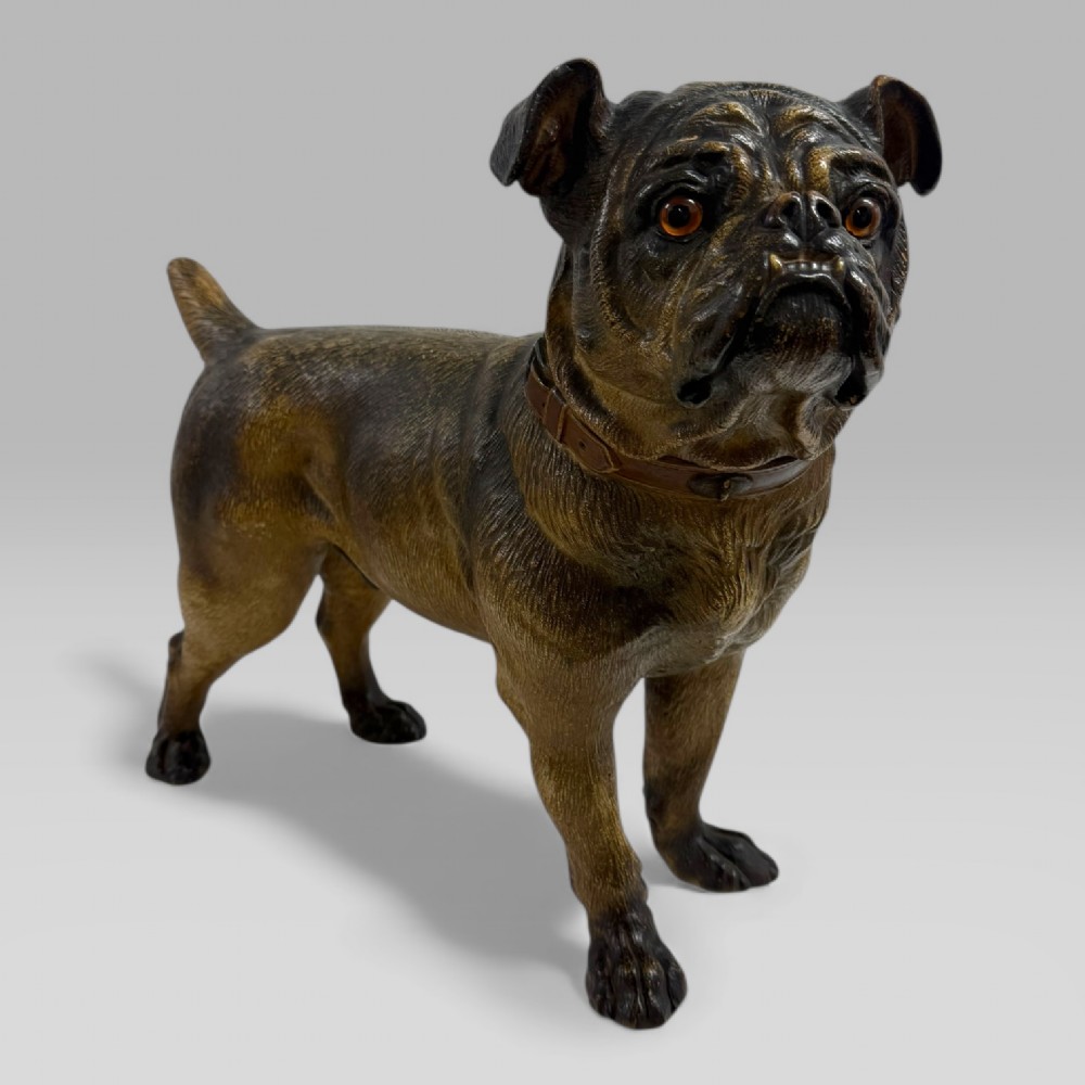 A life-size antique Austrian terracotta sculpture of a standing pug dog with inset glass eyes and a moulded collar.