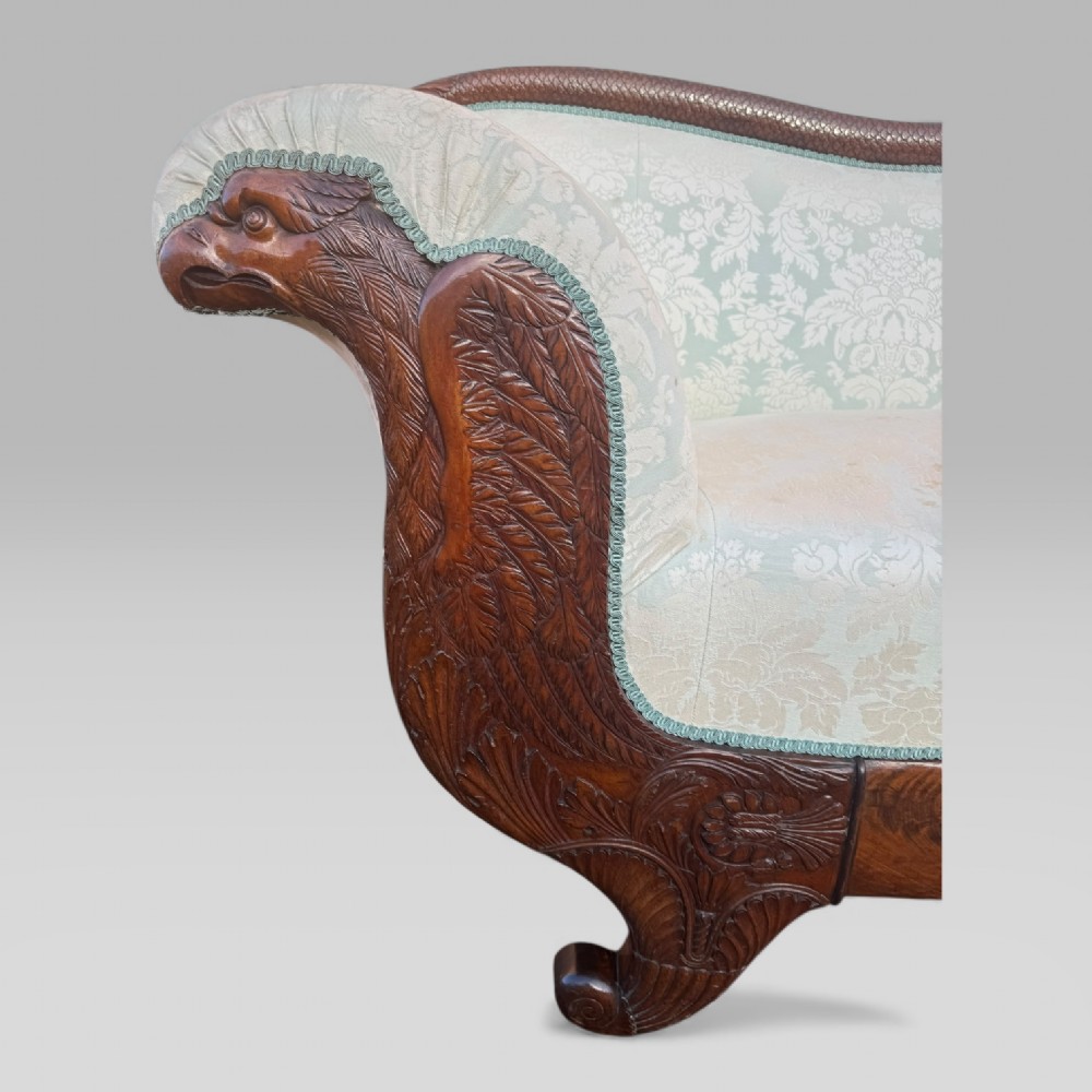 A nineteenth-century French Empire flame mahogany sofa featuring carved scroll arms, a serpentine crest, and light blue damask fabric upholstery. View VII