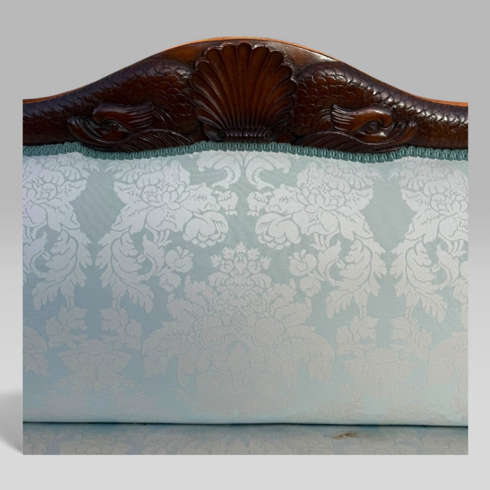 A nineteenth-century French Empire flame mahogany sofa featuring carved scroll arms, a serpentine crest, and light blue damask fabric upholstery. View VIII