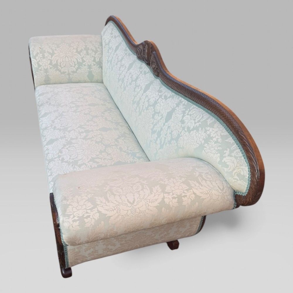 A nineteenth-century French Empire flame mahogany sofa featuring carved scroll arms, a serpentine crest, and light blue damask fabric upholstery. View X