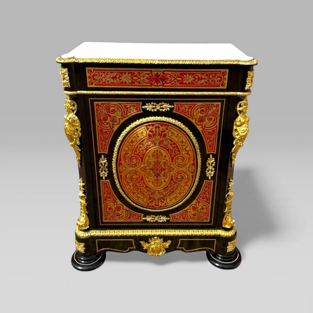 A French Napoleon III ebonised pier cabinet featuring red tortoiseshell and brass Boulle marquetry, gilt bronze mounts, and a white marble top.