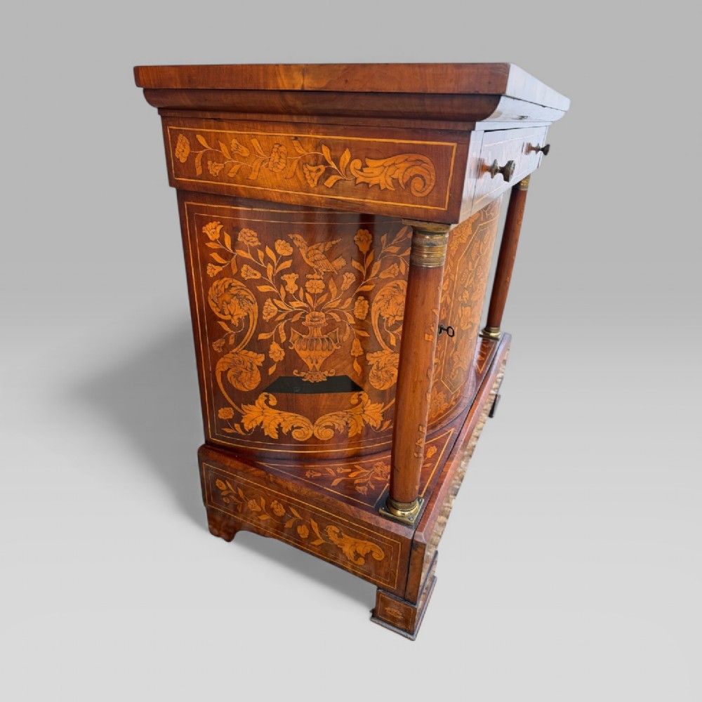 An 18th-century Dutch mahogany console table cabinet featuring detailed floral marquetry inlay, twin supporting columns, and a central cupboard door on a plinth base. View XI