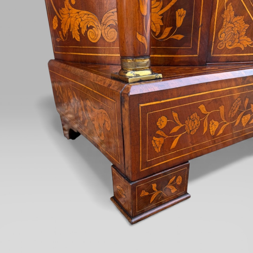 An 18th-century Dutch mahogany console table cabinet featuring detailed floral marquetry inlay, twin supporting columns, and a central cupboard door on a plinth base. View XII