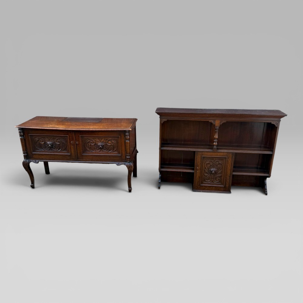 A late Victorian dark oak dresser with carved Green Man foliate motifs on the cupboard doors, open display shelving, and cabriole legs. View X