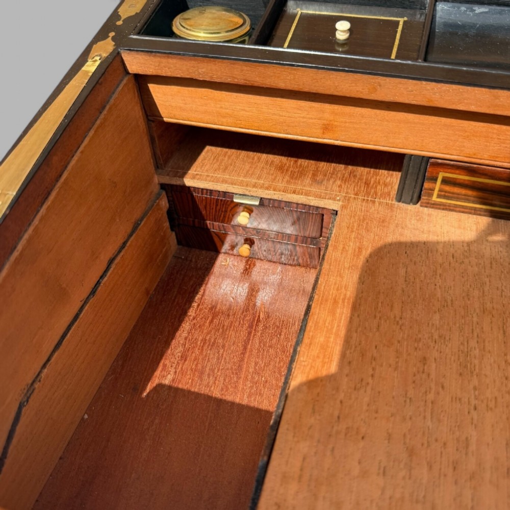 A rectangular dark timber writing slope featuring brass edge binding, intricate brass foliate inlay, a central brass nameplate, and a brass keyhole escutcheon. View XIII