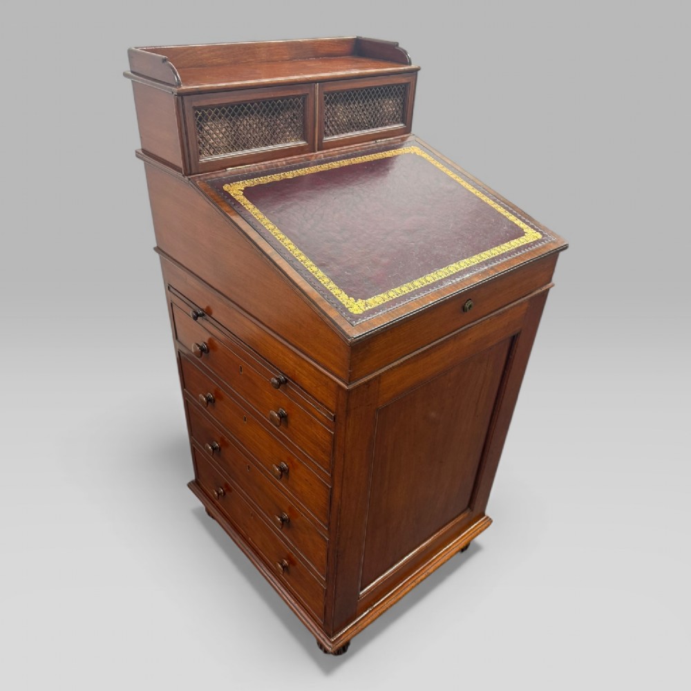 An antique mahogany Davenport desk featuring a sloped red leather writing surface, turned drawer knobs, and a top gallery superstructure. View II