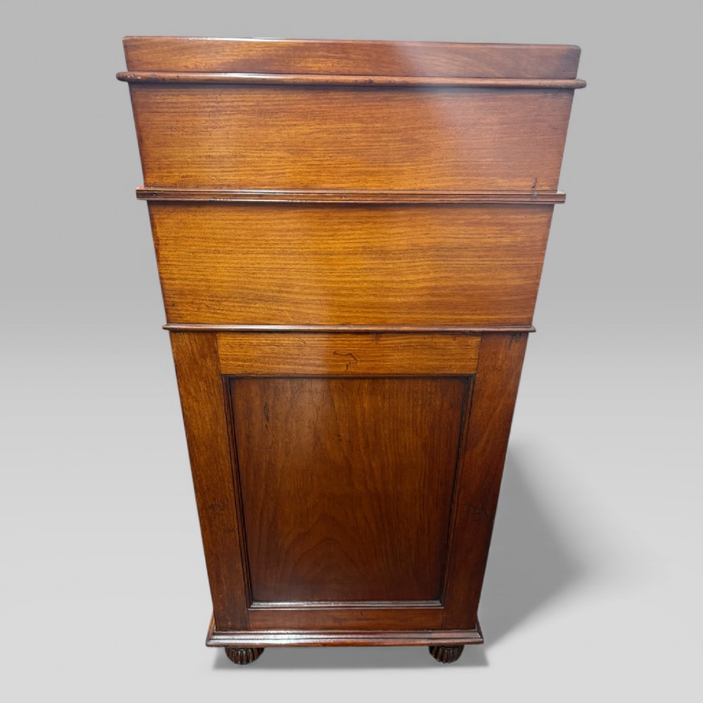 An antique mahogany Davenport desk featuring a sloped red leather writing surface, turned drawer knobs, and a top gallery superstructure. View IV