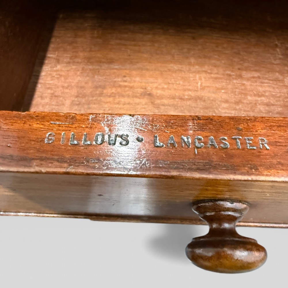 An antique mahogany Davenport desk featuring a sloped red leather writing surface, turned drawer knobs, and a top gallery superstructure. View IX