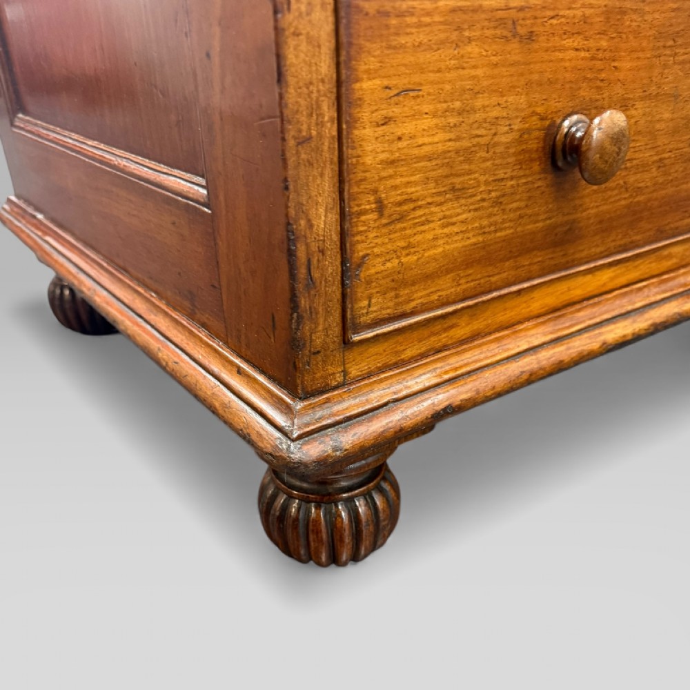 An antique mahogany Davenport desk featuring a sloped red leather writing surface, turned drawer knobs, and a top gallery superstructure. View XIII