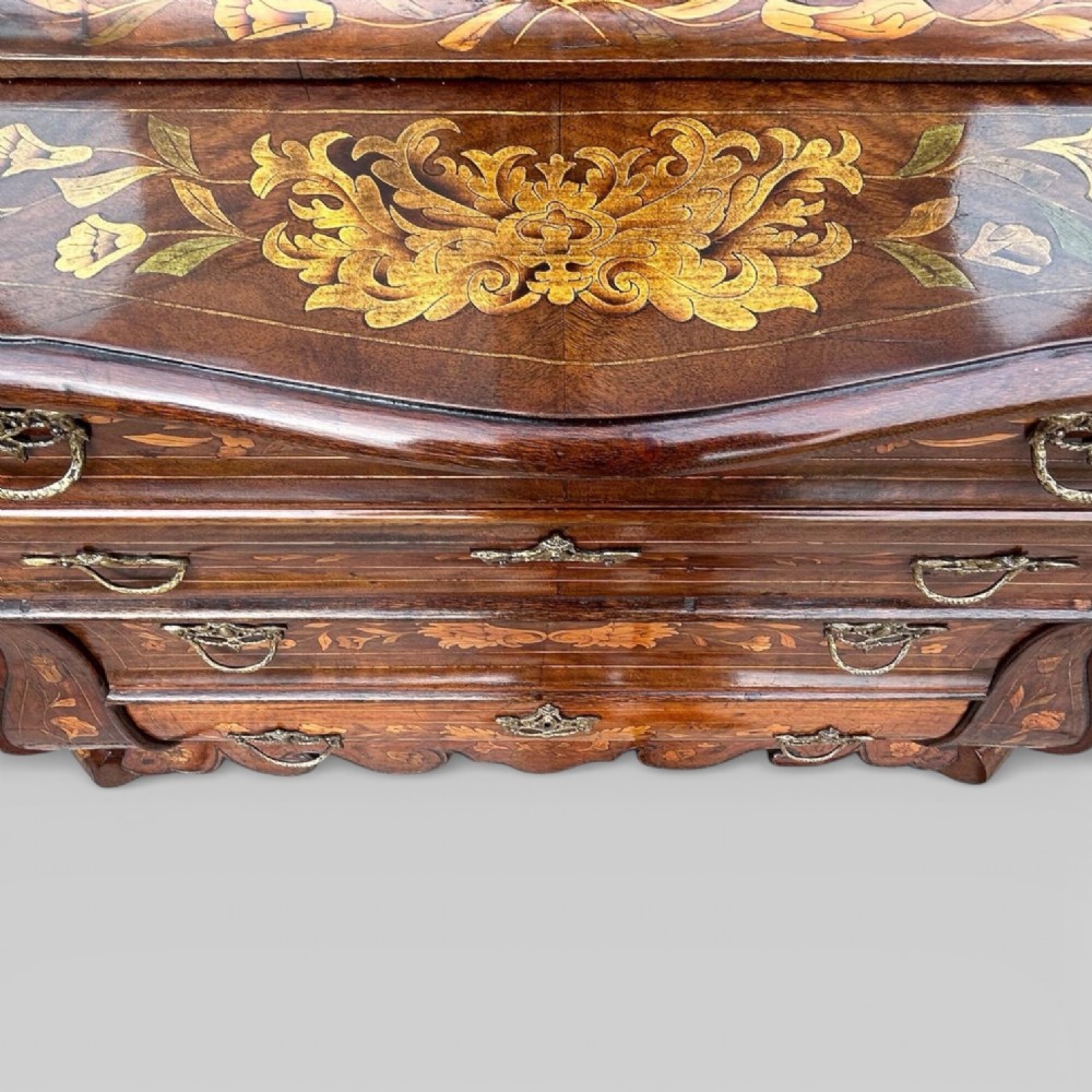An antique walnut display cabinet on a bombe chest of drawers featuring floral marquetry inlay, glazed doors, and brass handles. View IX