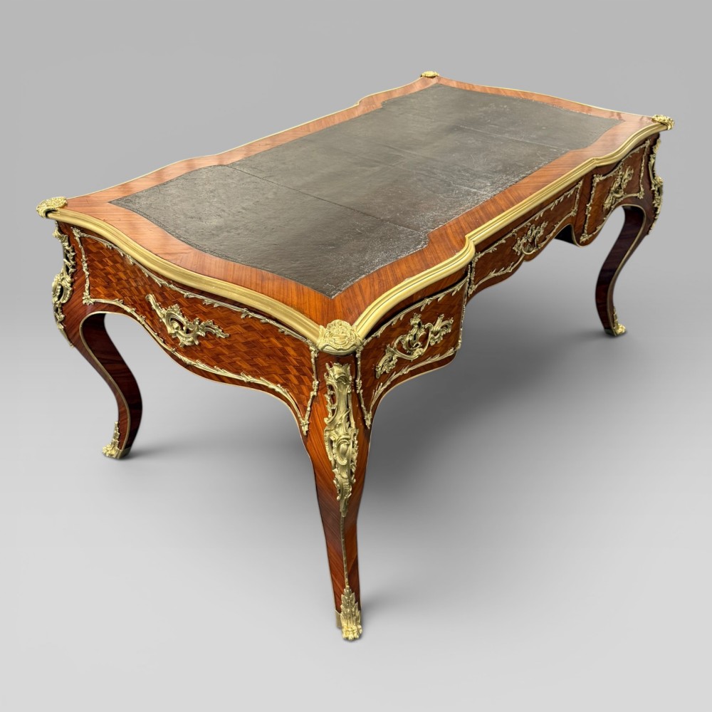A Louis XV style kingwood parquetry bureau plat featuring a dark leather writing surface, cabriole legs, and gilt-bronze ormolu mounts. View III