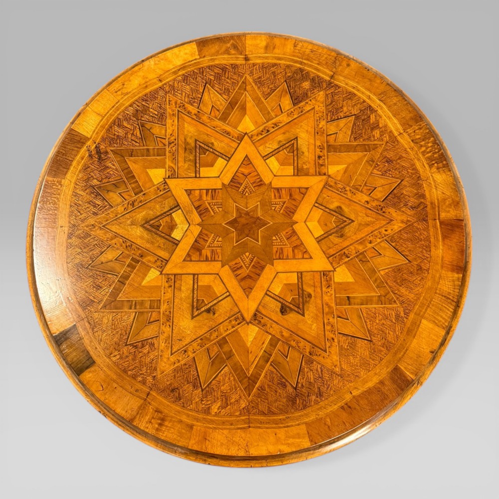 A circular antique side table featuring an intricate multi-timber geometric starburst marquetry pattern on top, set on carved cabriole legs with a triangular lower tier. View III
