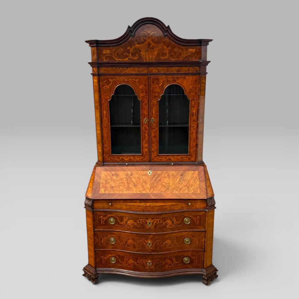 A mid-18th-century Italian Venetian bureau bookcase featuring detailed marquetry inlay, arched glazed doors, a slant-front writing desk, and three serpentine lower drawers.