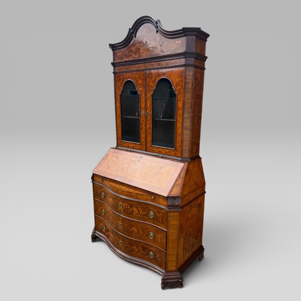 A mid-18th-century Italian Venetian bureau bookcase featuring detailed marquetry inlay, arched glazed doors, a slant-front writing desk, and three serpentine lower drawers. View IV